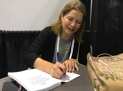 Dr. Myers autographing her new book The PNES Pocketbook 