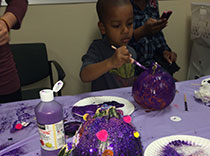 Kids painting pumpkins purple for epilepsy awareness