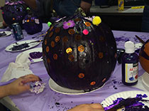 Busy hands paint pumpkins purple